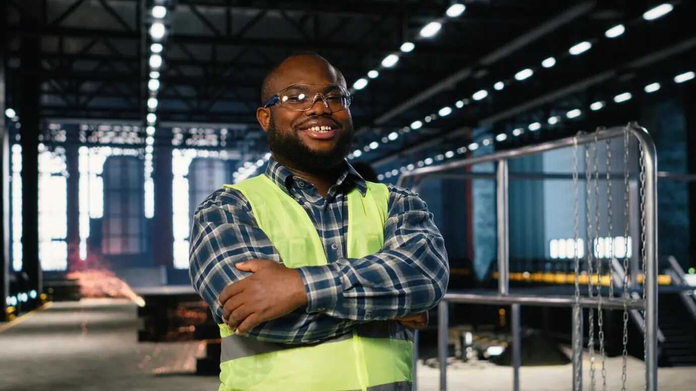 Fabrikpersonal inspiziert in einer Werkshalle Maschinen aus Stahl, wobei die Professionalität der Arbeit hervorgehoben wird.