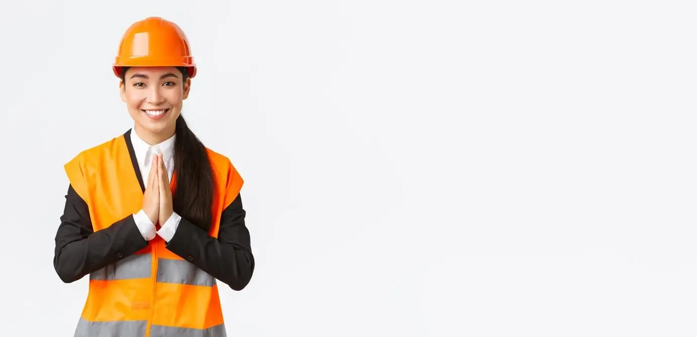 Eine lächelnde, dankbare asiatische Architektin, die das Vertrauen ihrer Kunden schätzt, hält die Hände in einer bittenden Geste gefaltet und bedankt sich bei jemandem.